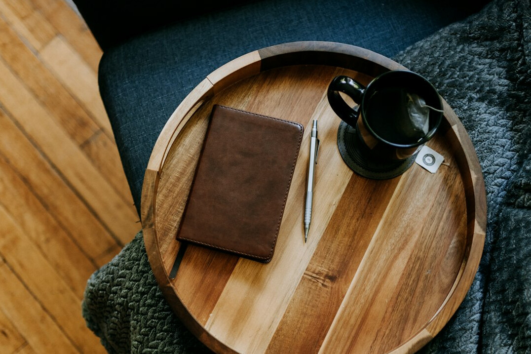 Open journal with a pen and a cup on a table
